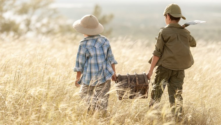 Kinder mit Schatzkiste in einem Getreidefeld