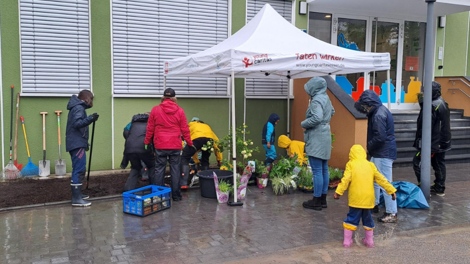 Engagierte und Kinder beim Blumenpflanzen