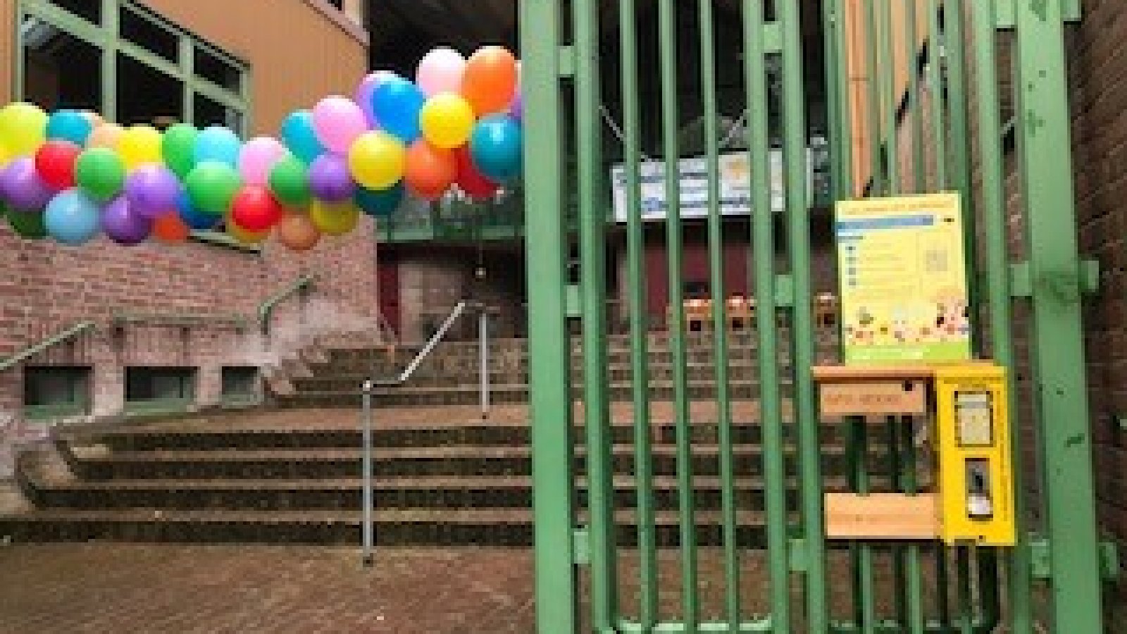 Bunte Ballon Girlande neben Bienenfutterautomat