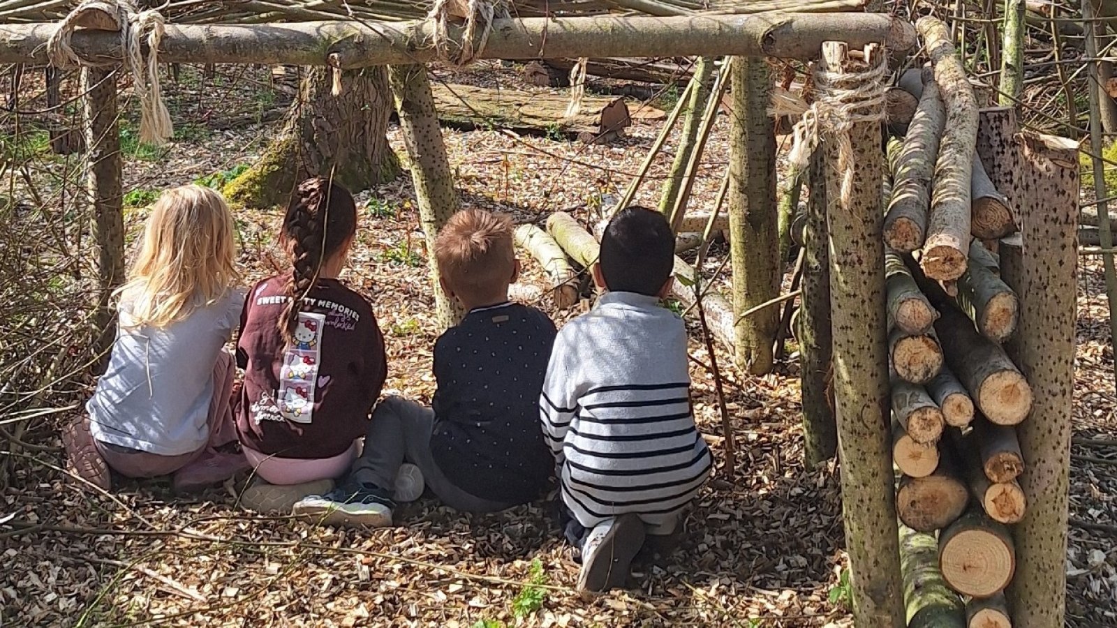Kinder mit dem Rücken zur Kamera im Wald