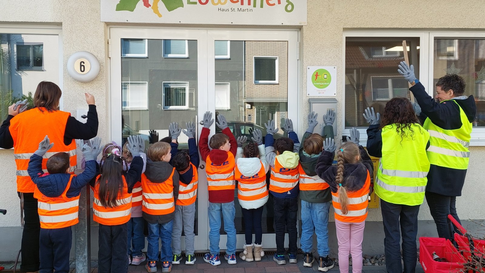 Kinder mit Westen und Zangen mit dem Rücken zur Kamera