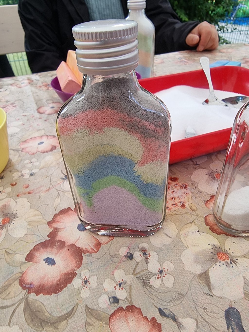 Kleine Glasflasche mit buntem Salz